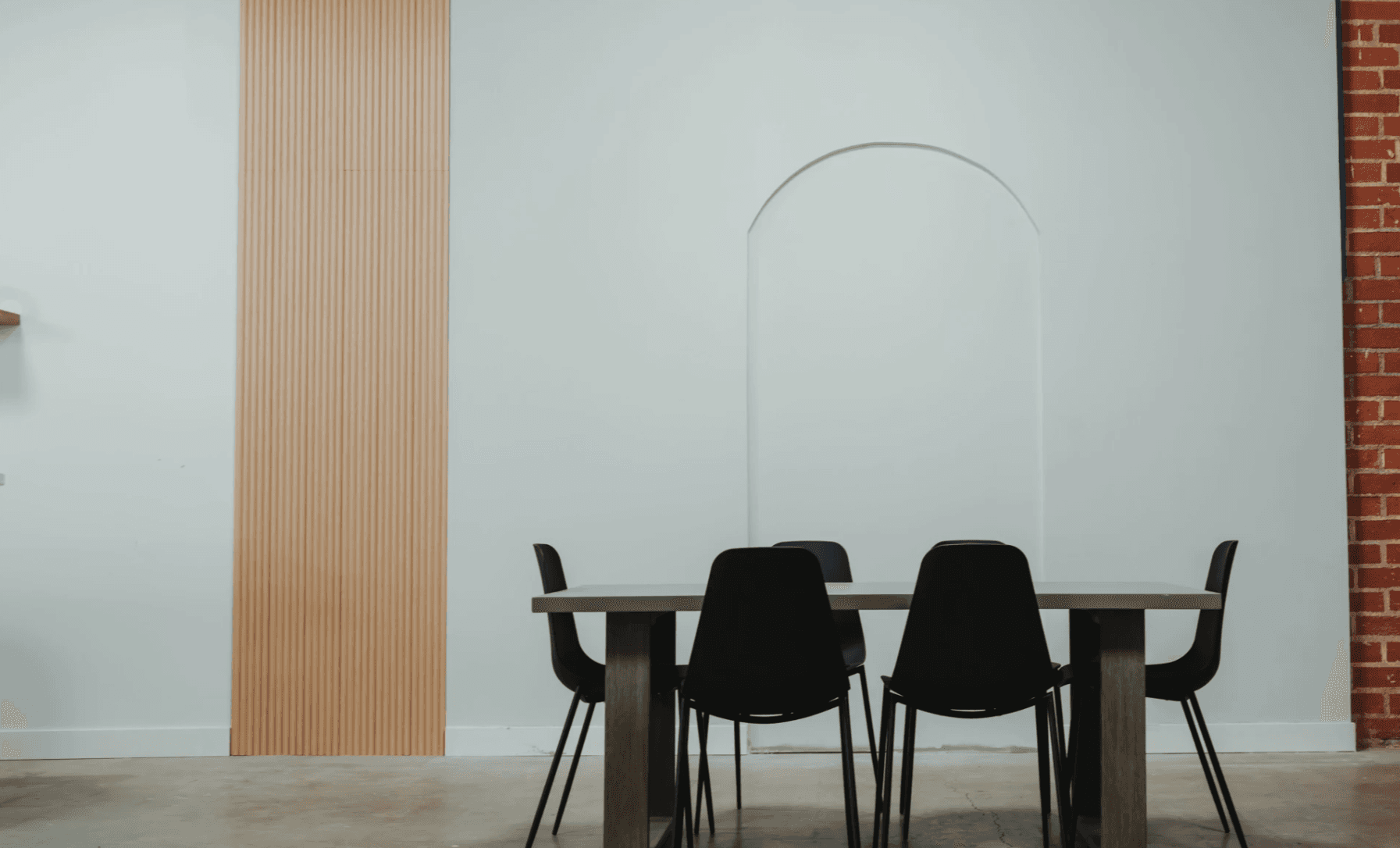Dining room set with architectural arch and black chairs for editorial brand photography — Los Angeles content studio